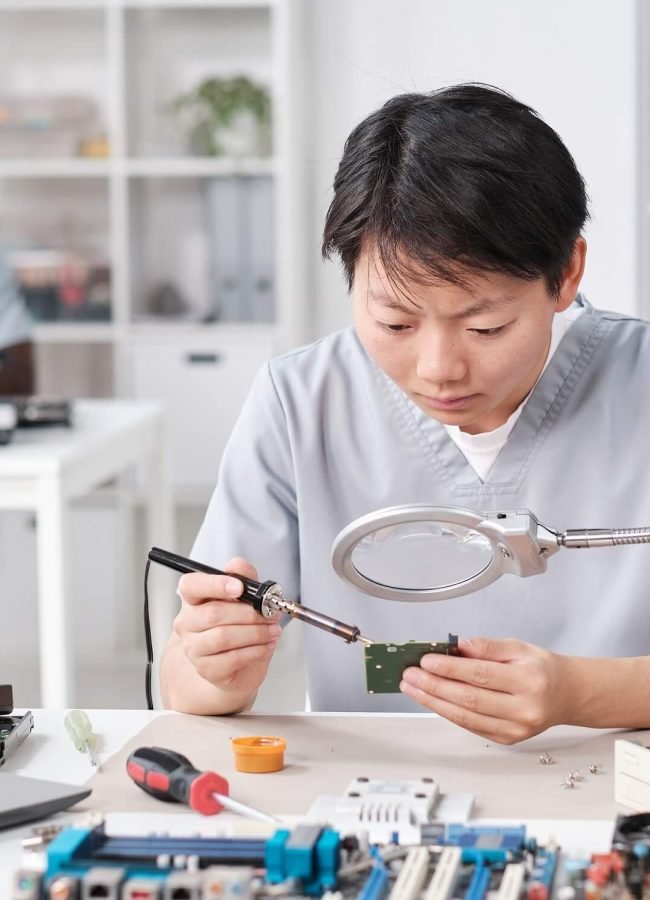 asian-woman-in-uniform-soldering-circuit-board-2021-12-09-20-54-55-utc.jpg